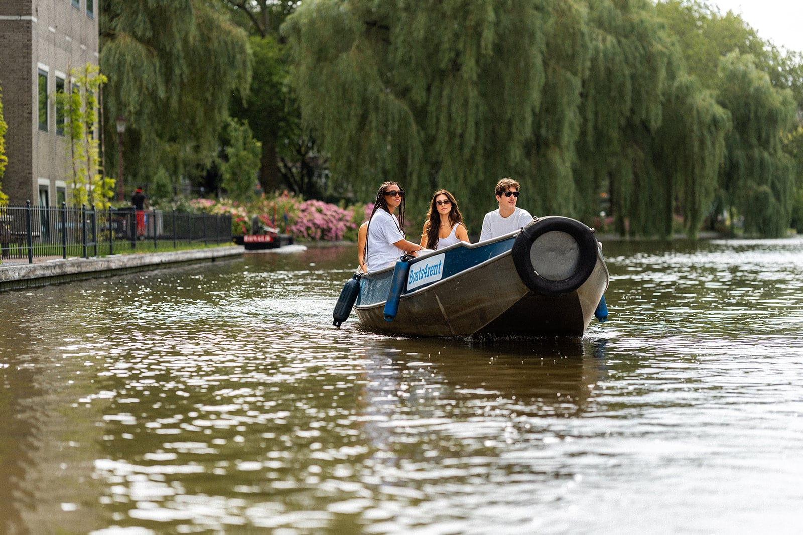 Friends enjoying a boat rental on the Amsterdam canals — ideal as a gift voucher